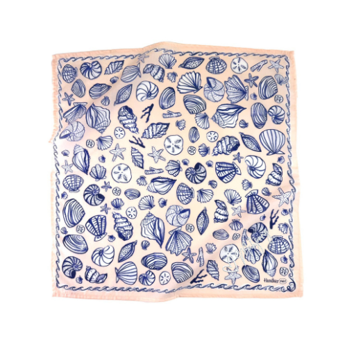 A square scarf featuring a blue seashell-and-starfish pattern on a peachy-pink background, with a matching pink border. Look closer & you will see the white heart and mahjong-embroidered script in the corner.
