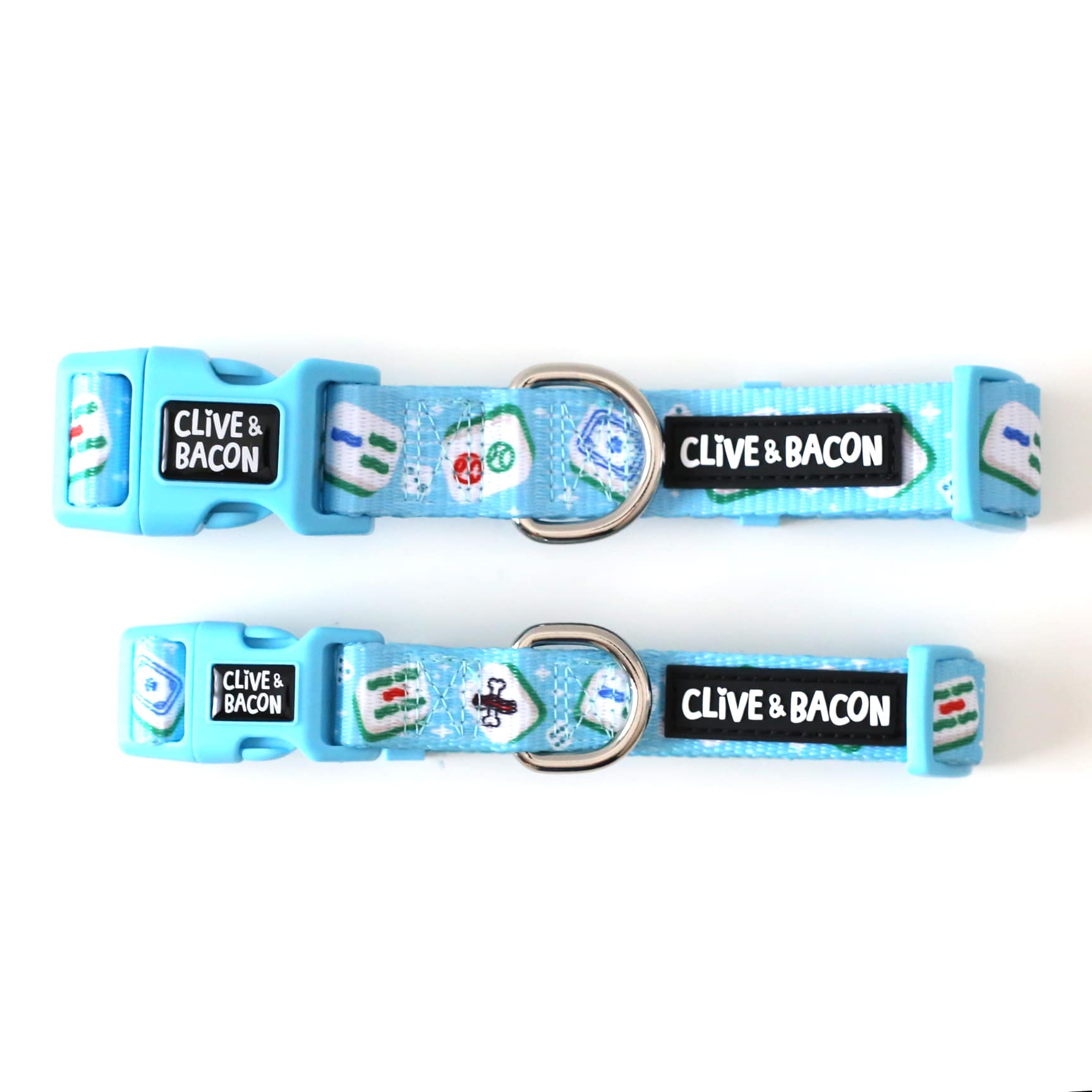 Two bright blue dog collars with a glossy polyester webbing finish, decorated with mahjong tile graphics and a black label that reads 'CLIVE & BACON'.