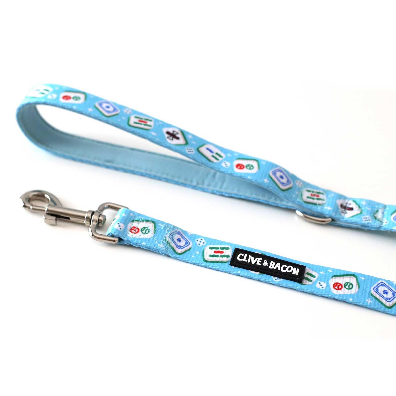 A bright blue fabric dog leash with a printed pattern of various food icons and a black label that reads 'CLIVE & BACON'. The leash has a silver metal swivel snap hook at one end and is photographed on a plain white background.
