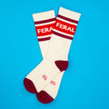 White socks with red accents and 'FERAL' text on a blue background