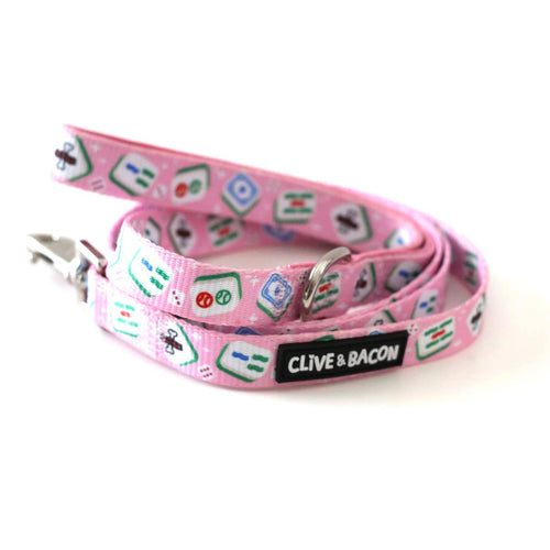 A pink pet leash with a repeating pattern of mahjong tiles and a black brand label reading 'CLIVE & BACON', photographed on a white background.