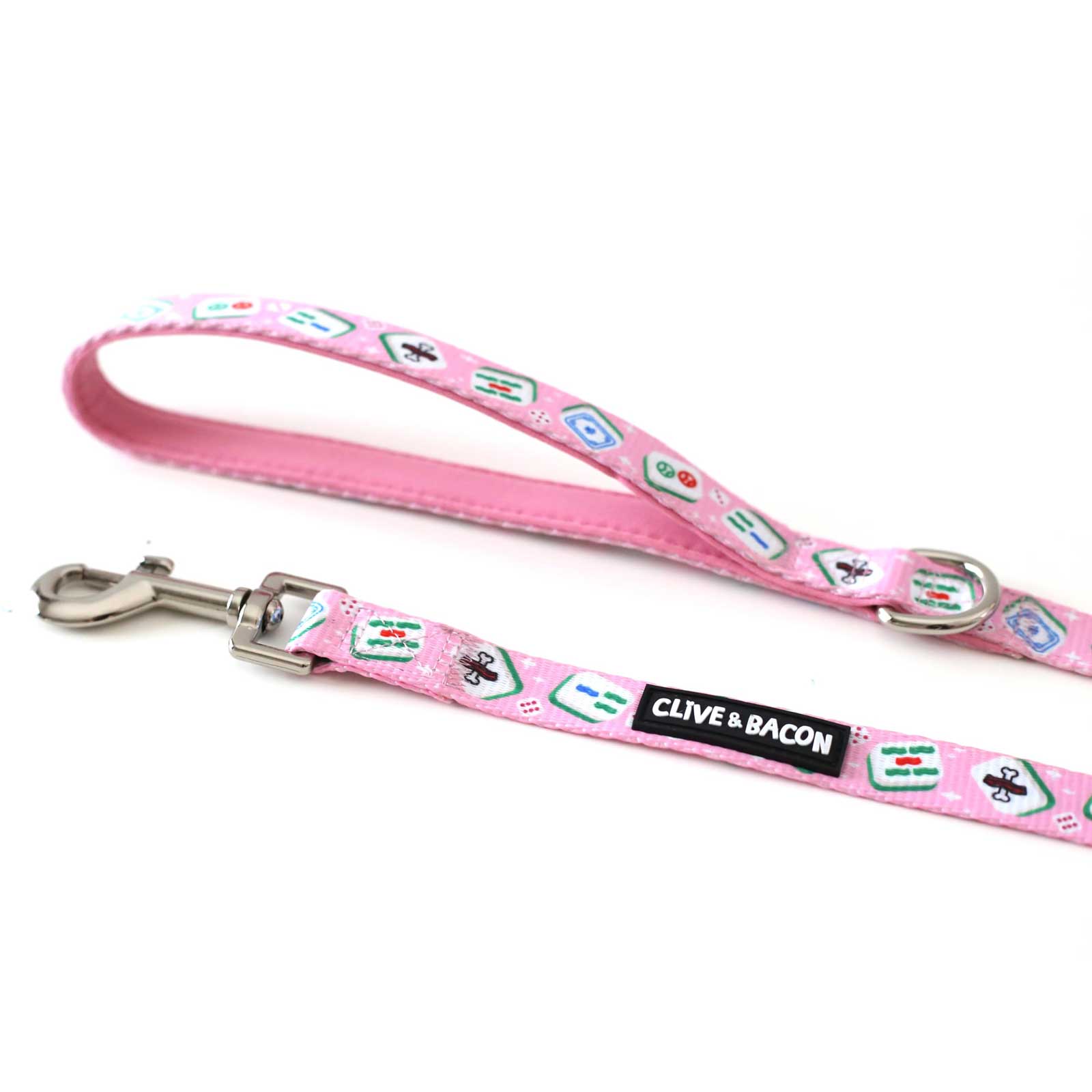 A pink dog leash with a pattern of mahjong tiles, featuring a black brand label that reads 'CLIVE & BACON' and a silver metal clasp, shown on a white background.