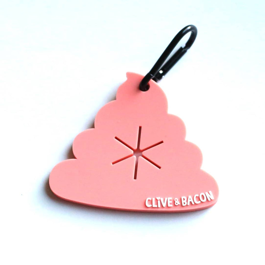 A pink poop-shaped keychain or bag charm with a black carabiner clip. The word 'CLIVE & BACON' is printed in white on the bottom right, and there is a starburst cutout in the center.